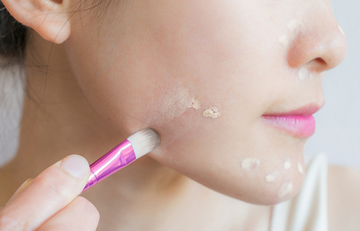 Woman applying concealer to hide signs of aging and look baby-like