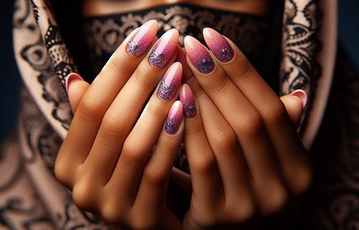 Light pink ombré nails with bluish-purple glitter