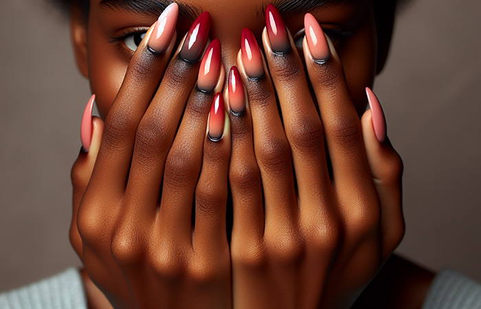 Red and pink ombré nails with hints of black at the cuticles