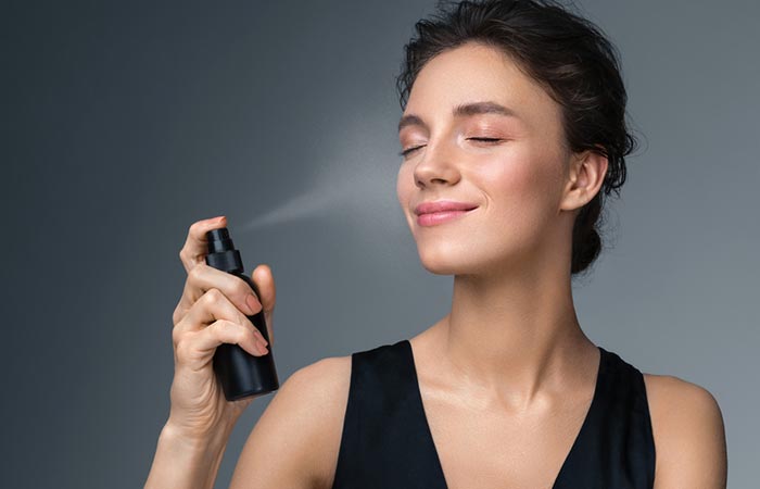 Woman using a setting spray on her face to avoid cakey makeup